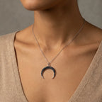 Scale reference of the Luna Dura black zircon crescent necklace worn on a model to demonstrate the 21x18mm pendant size and 40cm length