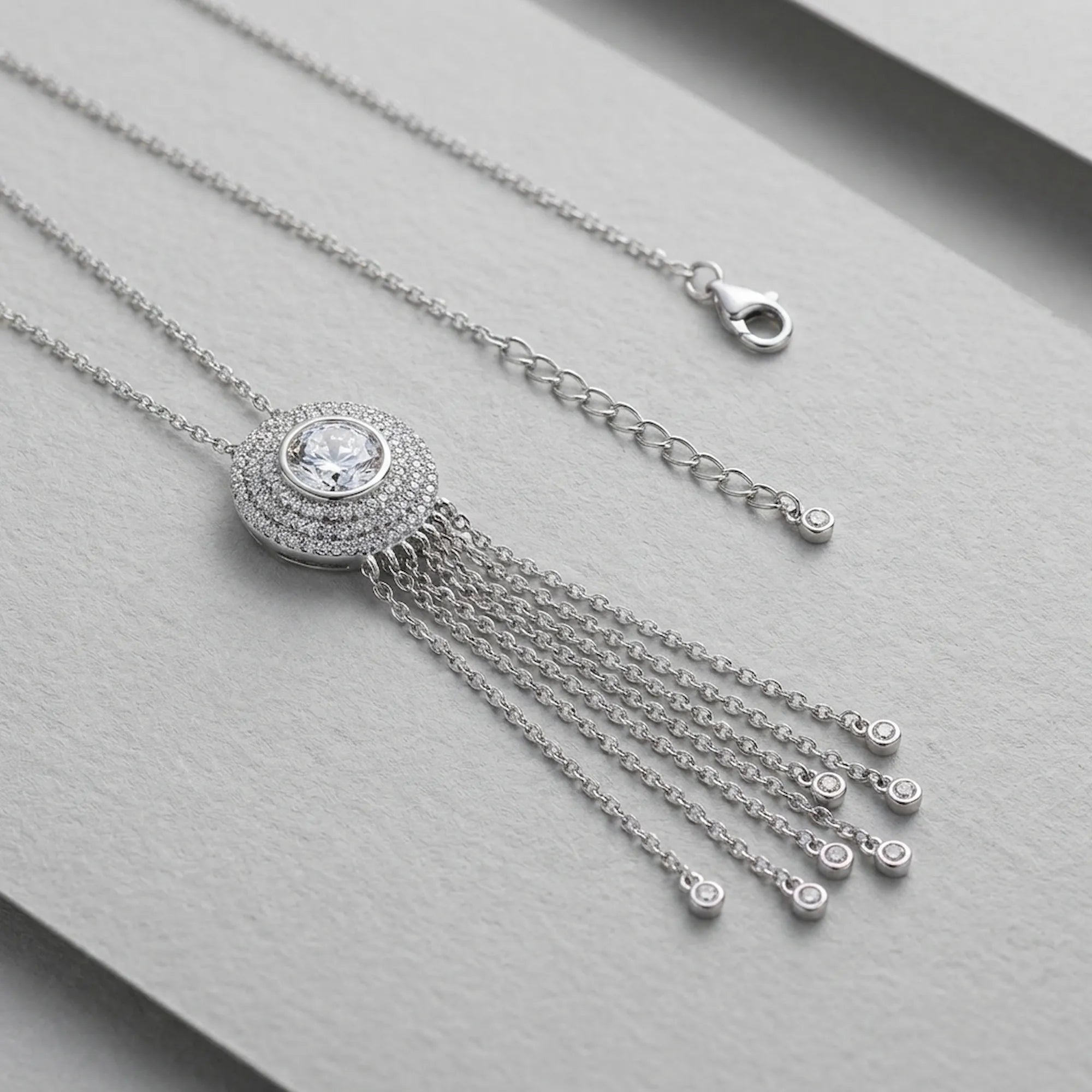 Frontal side view of the Surayya pave-set circle tassel necklace, highlighting the premium rhodium finish and liquid-silver chain closure lobster claw