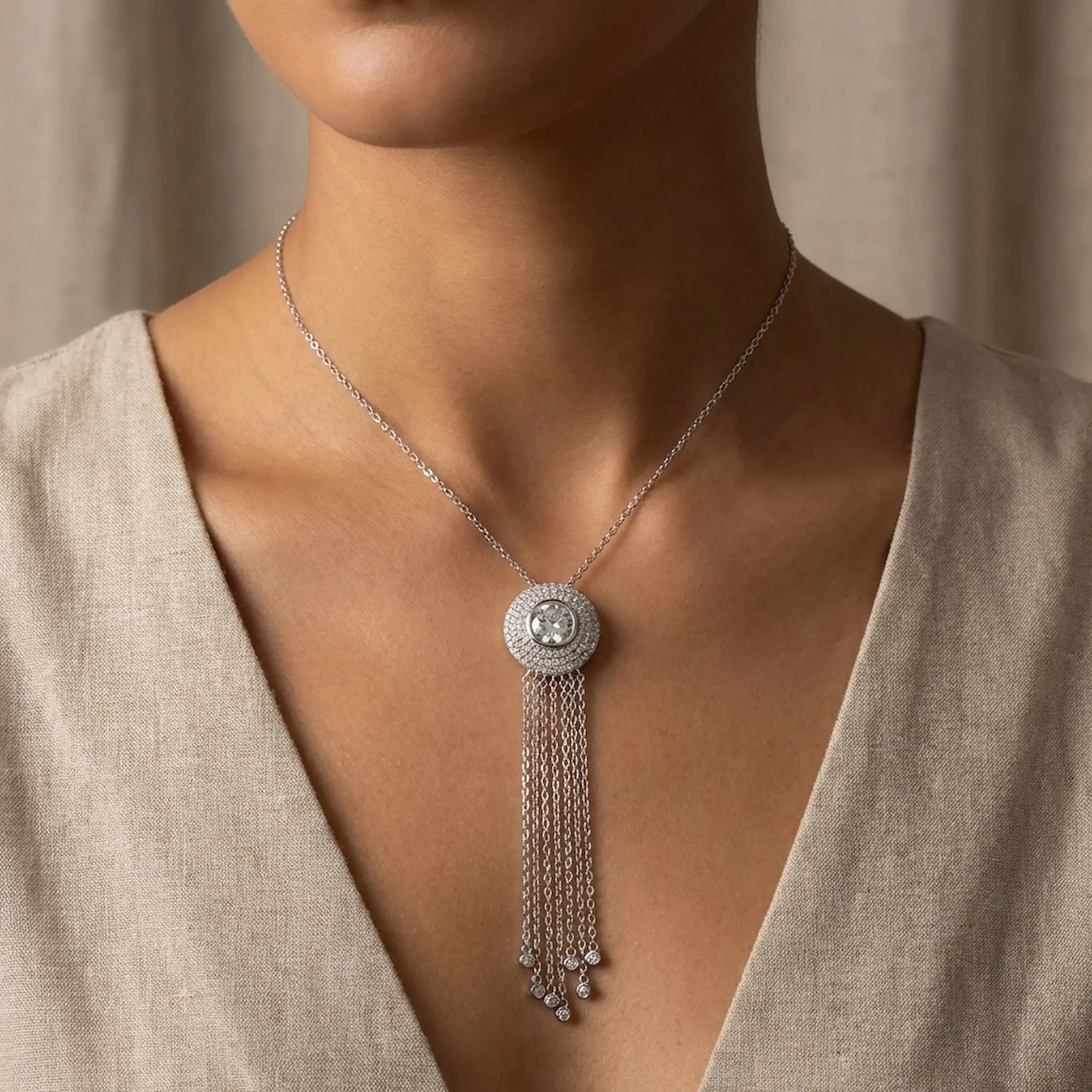 Scale reference of the Surayya silver tassel necklace worn on a model to demonstrate the 17mm pendant size and shimmering chandelier drop