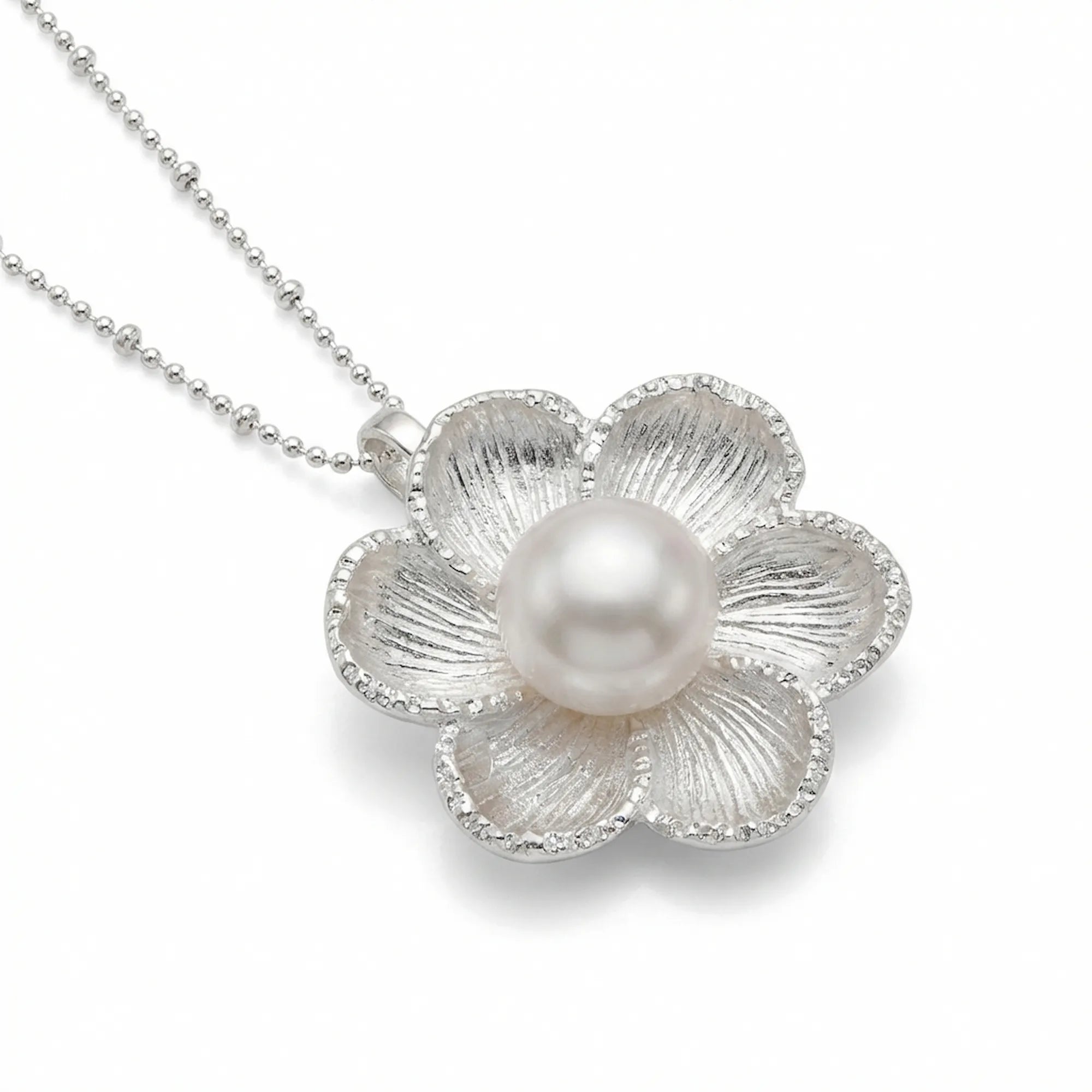 925 silver magnolia pendant with freshwater pearl, 3/4 angle showing petal depth and milgrain edge