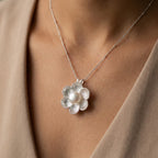 Magnolia pearl pendant necklace by Luna Dura Dubai, worn at neckline over taupe fabric