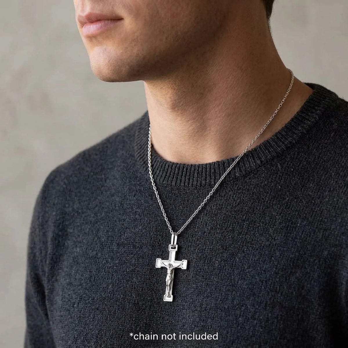 Man wearing a Made in Italy sterling silver crucifix pendant, styling chain not included.