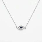 Minimalist blue CZ evil eye station necklace in polished 925 silver on white, showing its curved openwork eye motif.