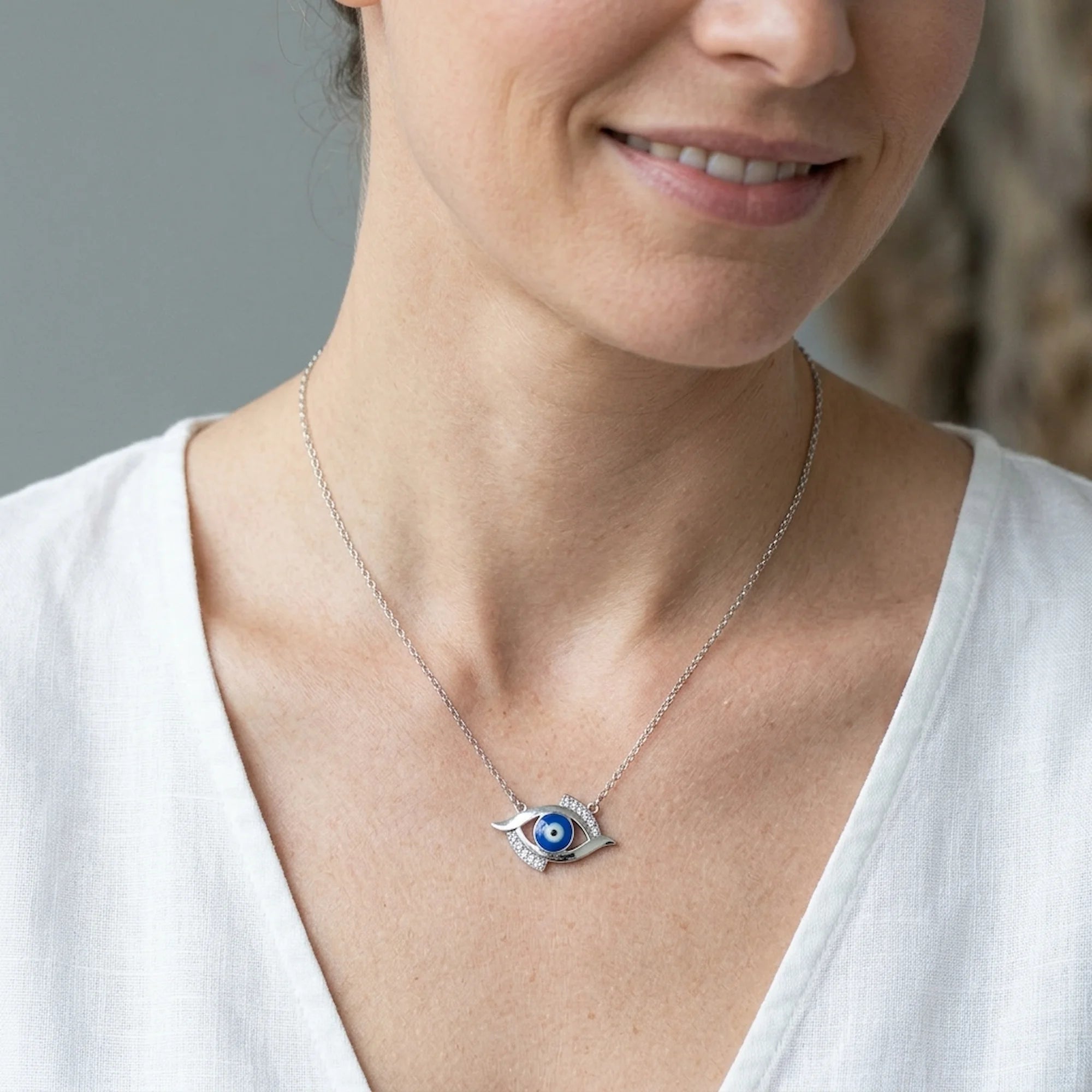 Woman wearing a minimalist 925 silver blue evil eye necklace for everyday wear in dubai.