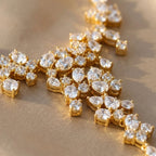 Macro view of an 18k gold-plated cubic zirconia waterfall necklace showing mixed-cut stones on silk fabric in Dubai.