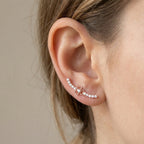 A model wearing the small 10mm sterling silver ear cuff near the lower lobe, demonstrating the subtle scale and precise fit for daily wear.