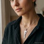 Woman wearing a mirror-polished modern Christian pendant with embossed Christ figure, chain not included