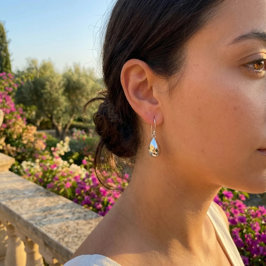 Model wearing Molten Drop silver teardrop earrings outdoors in warm garden light — everyday 925 sterling silver drop earrings Dubai