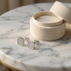 Rhodium 925 sterling silver mosaic pavé cubic zirconia stud earrings by a cream box on marble — square pavé face