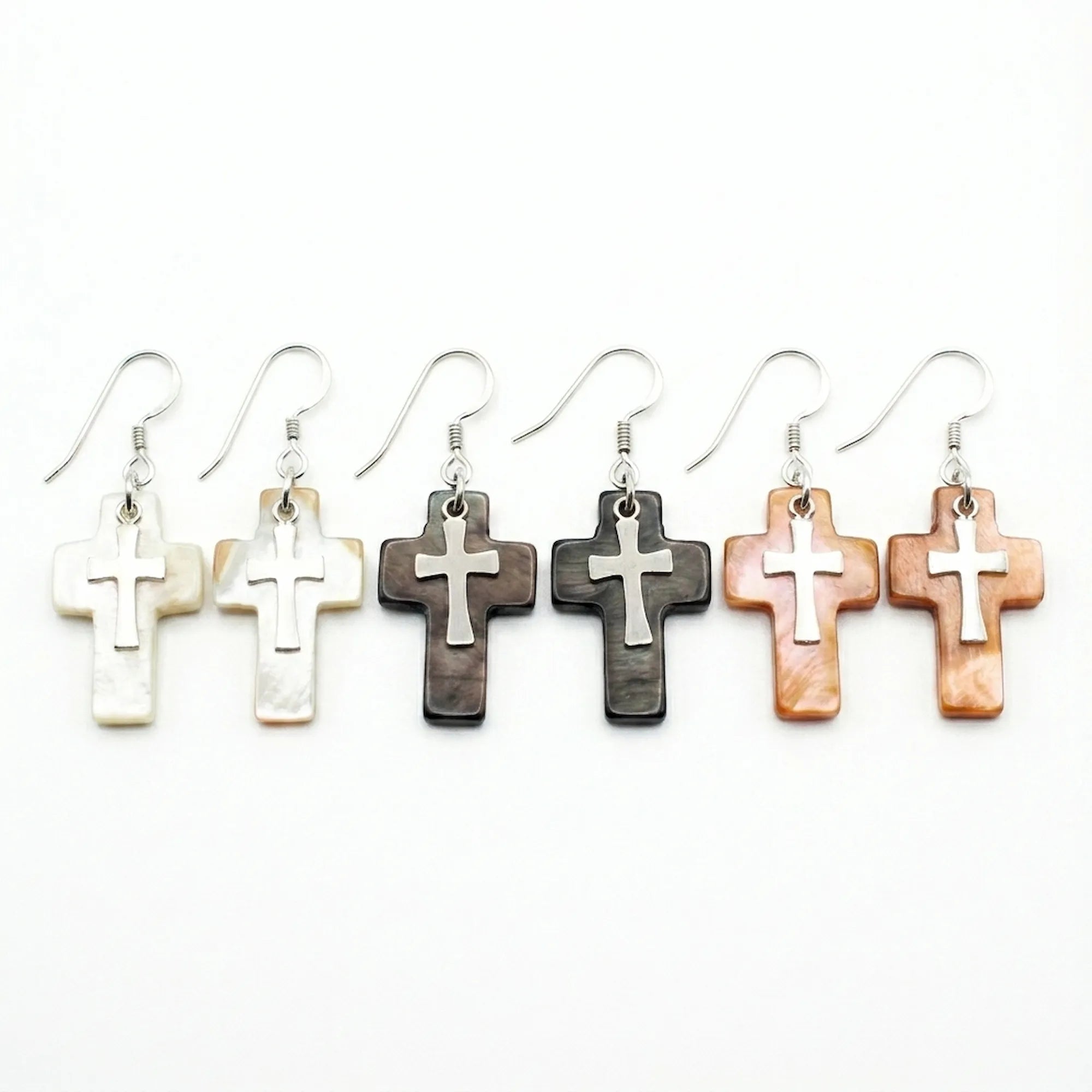 Natural shell cross drop earrings in three colorways — white lip oyster, Tahitian black and winged oyster brown — 925 silver crucifix on white background