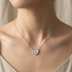 Mother of Pearl heart necklace worn at collarbone on model in linen top — CZ halo and bow detail visible, rhodium 925 silver Dubai