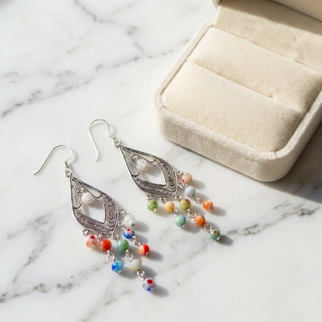 Murano glass chandelier earrings beside a cream velvet gift box, Luna Dura Dubai.