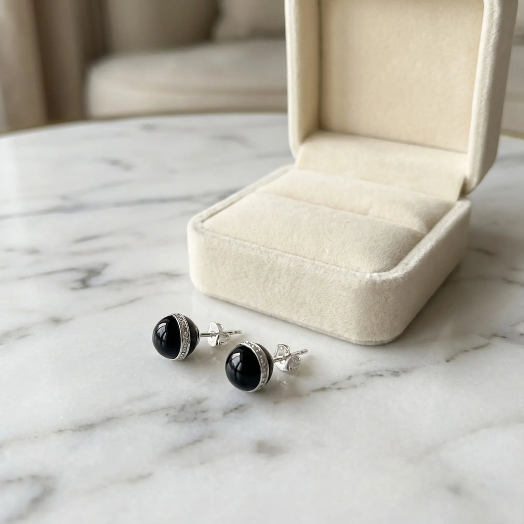 Orbital black CZ halo stud earrings beside a cream gift box, gift-ready from Luna Dura Dubai