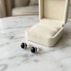 Orbital black CZ halo stud earrings beside a cream gift box, gift-ready from Luna Dura Dubai