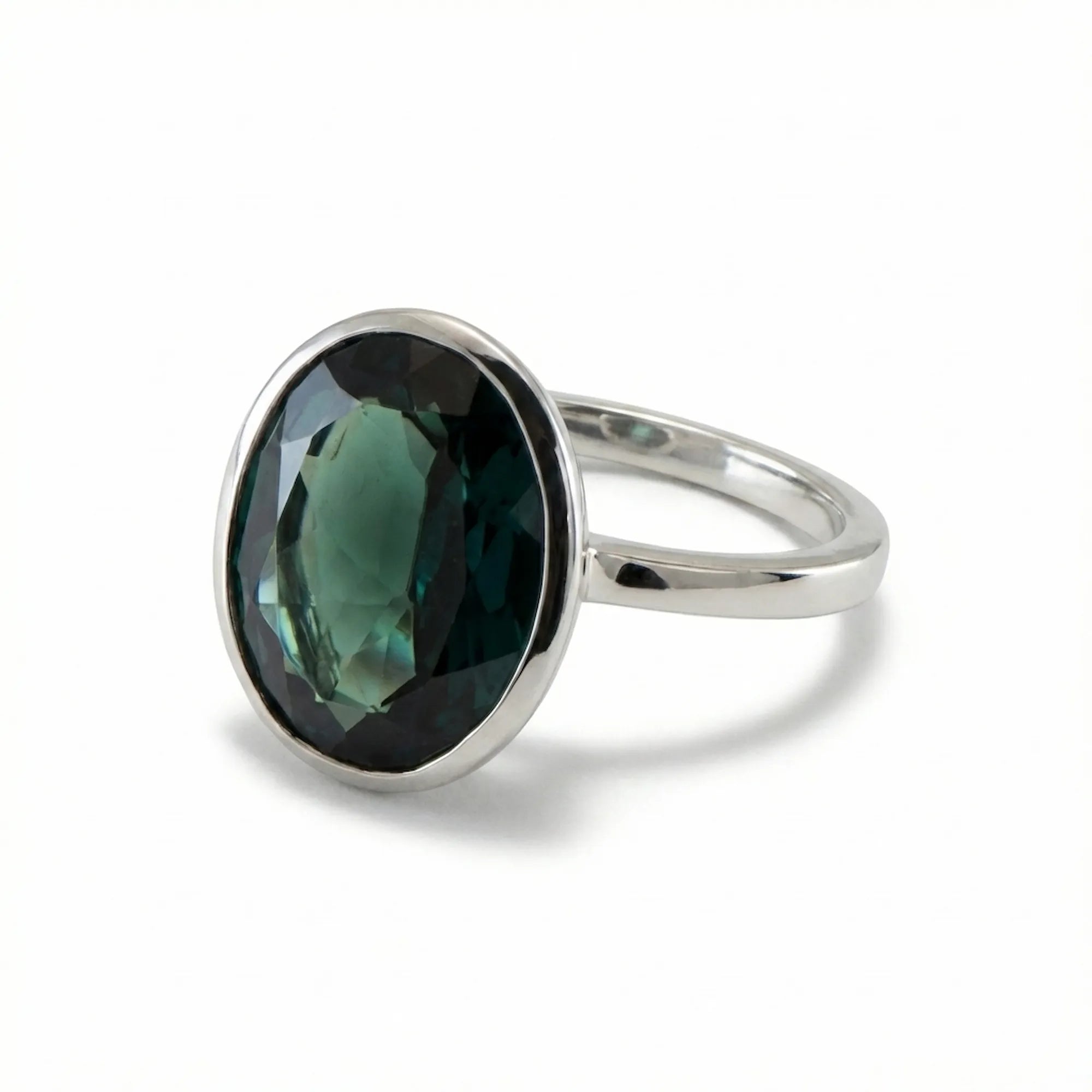 Angled view of the elegant November birthstone jewelry showing the smooth 925 sterling silver bezel protecting the London Blue Topaz.