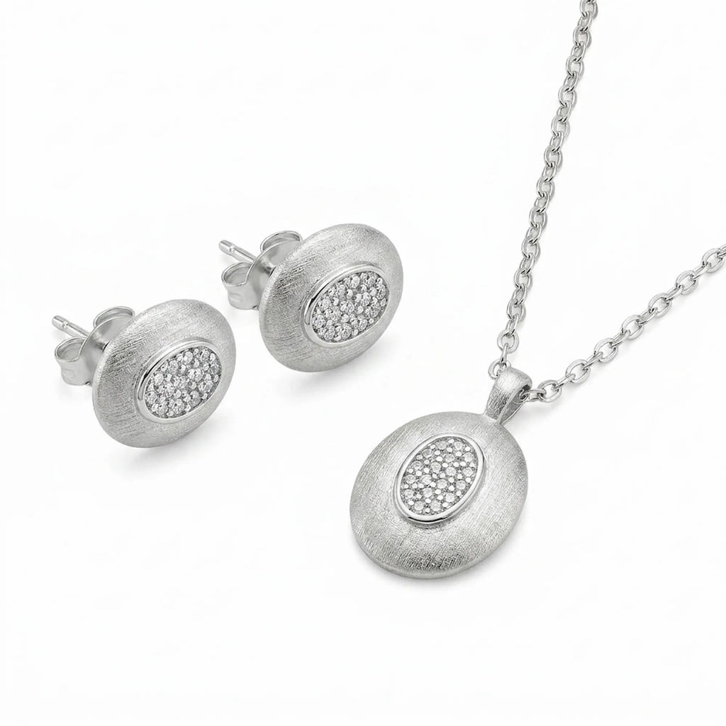 Brushed rhodium oval pendant necklace and matching CZ pavé stud earrings in 925 sterling silver — white background