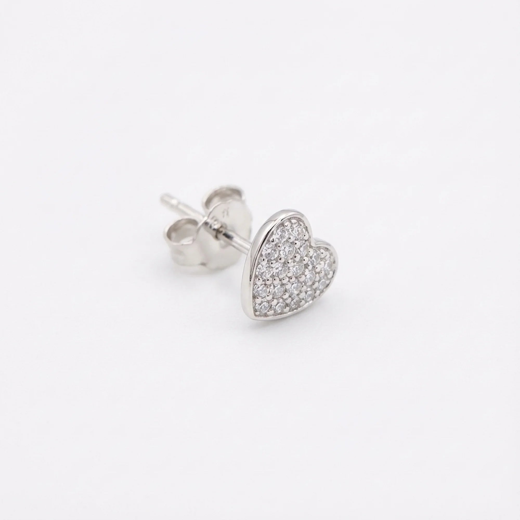 Side view of the pavé heart stud earring showing the polished post and butterfly back in 925 sterling silver.