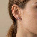 Model wearing the pavé heart stud with the open heart wire frame encircling the earlobe, in sterling silver.