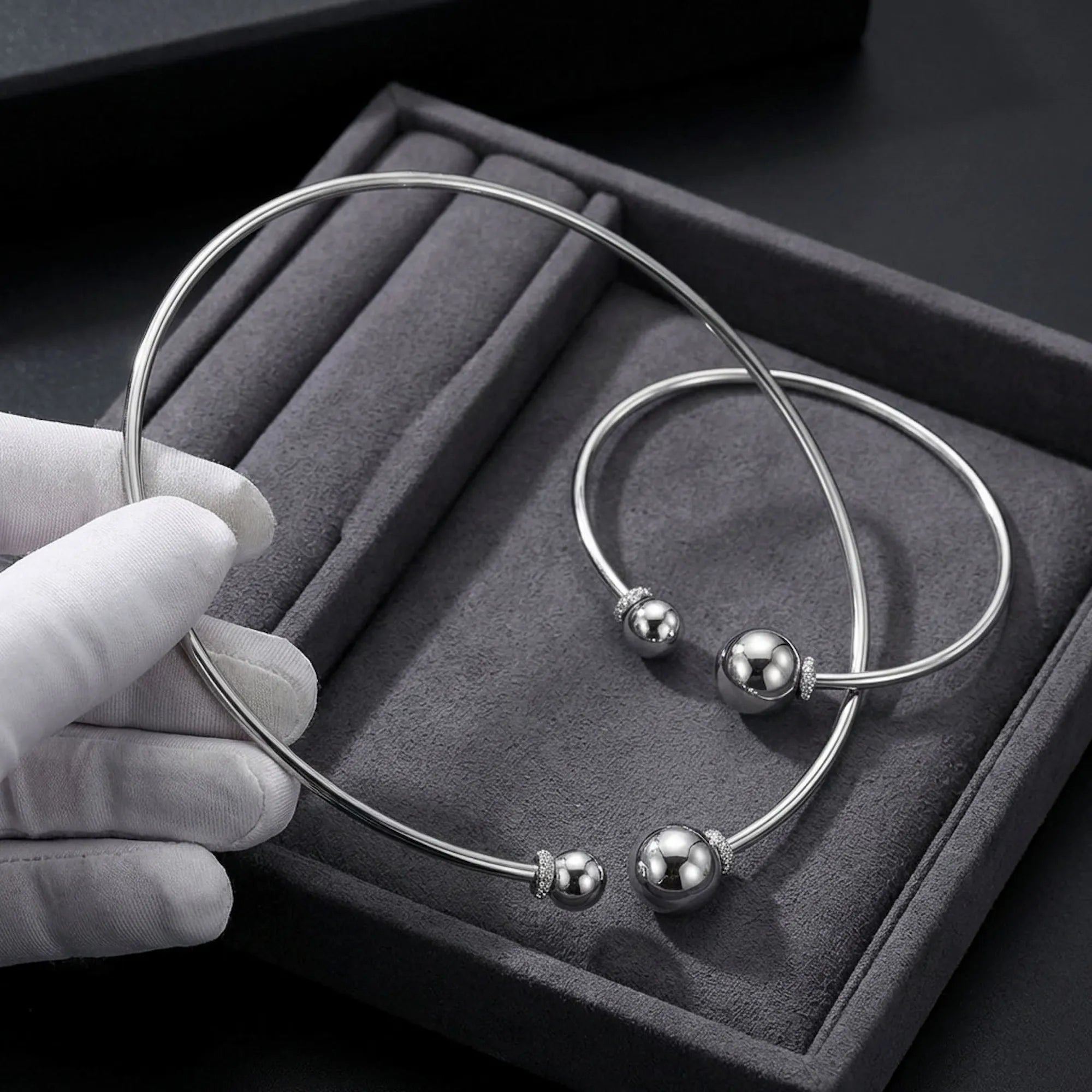 Close up detail of the solid 925 silver and pave cz spheres on the sterling silver choker resting in a plush display box.