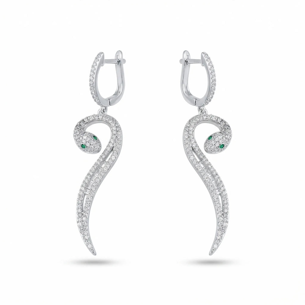 Paved serpent drop earrings in rhodium 925 silver — green CZ eye, mixed round and baguette cubic zirconia, white background
