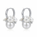 925 sterling silver pearl drop huggie earrings from Luna Dura Dubai, carved white flowers and cubic zirconia above a round pearl drop.