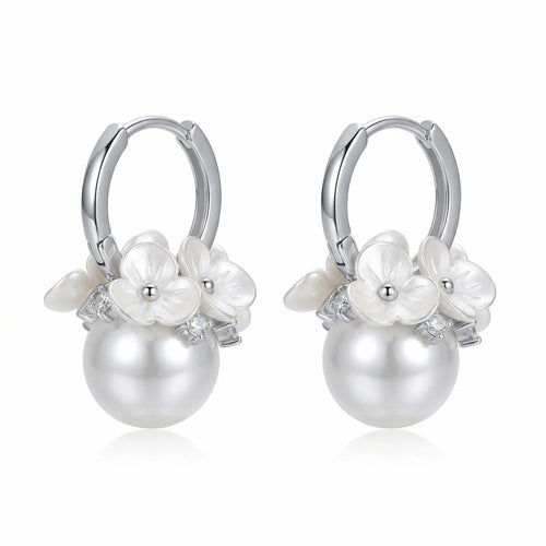 925 sterling silver pearl drop huggie earrings from Luna Dura Dubai, carved white flowers and cubic zirconia above a round pearl drop.