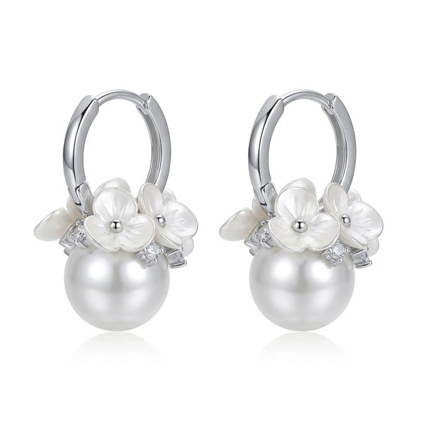 Pair of silver huggie earrings, each with carved white flowers and a cubic zirconia accent above a round pearl drop.