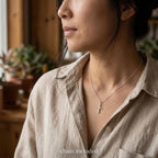 Woman wearing a plain silver cross necklace with small polished Latin cross and included chain.