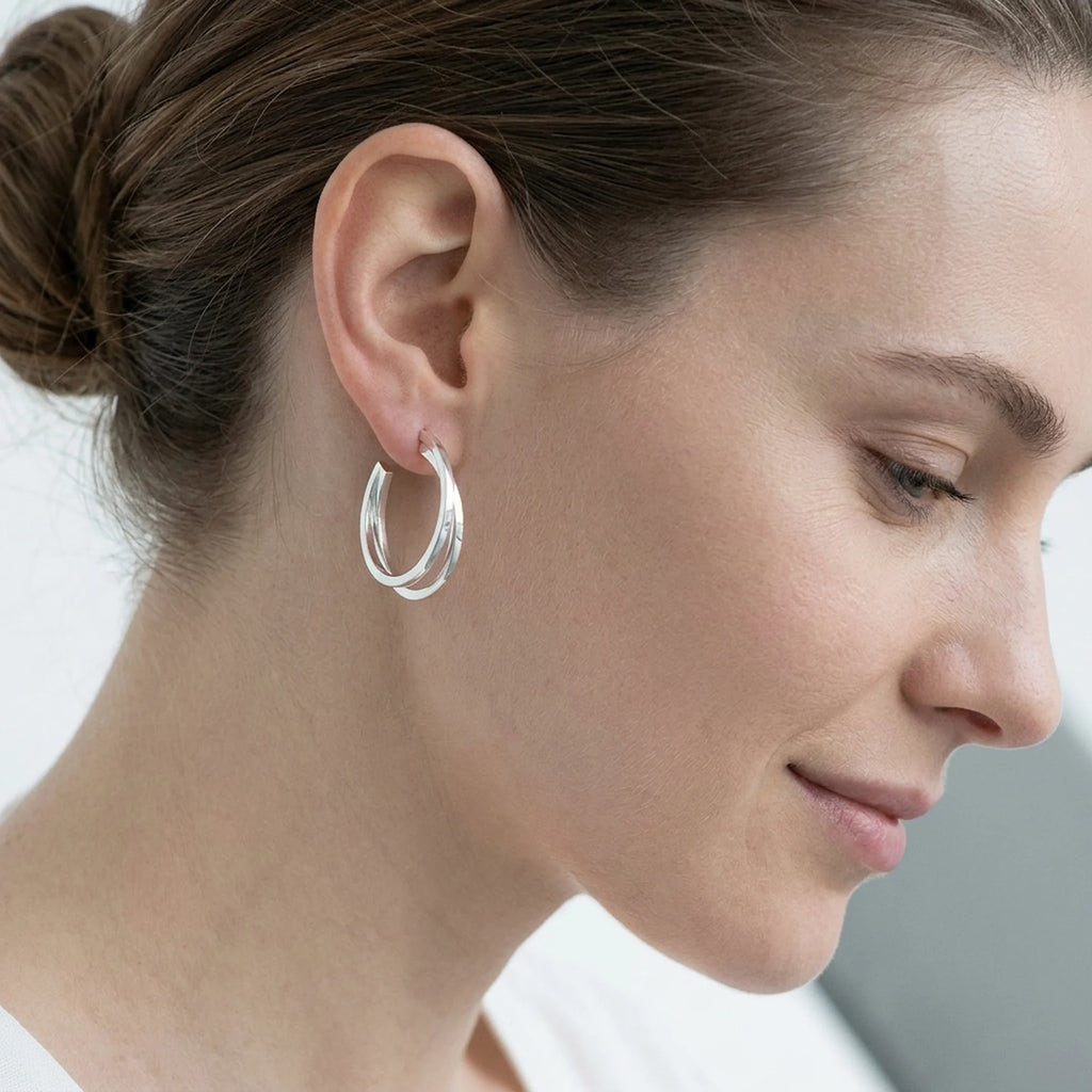Woman wearing bright polished 925 sterling silver split hoop earrings, available in Dubai.