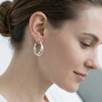 Woman wearing bright polished 925 sterling silver split hoop earrings, available in Dubai.