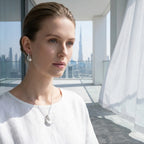 Rhodium silver puffed heart drop earrings and pendant necklace worn in Dubai — cool skin model