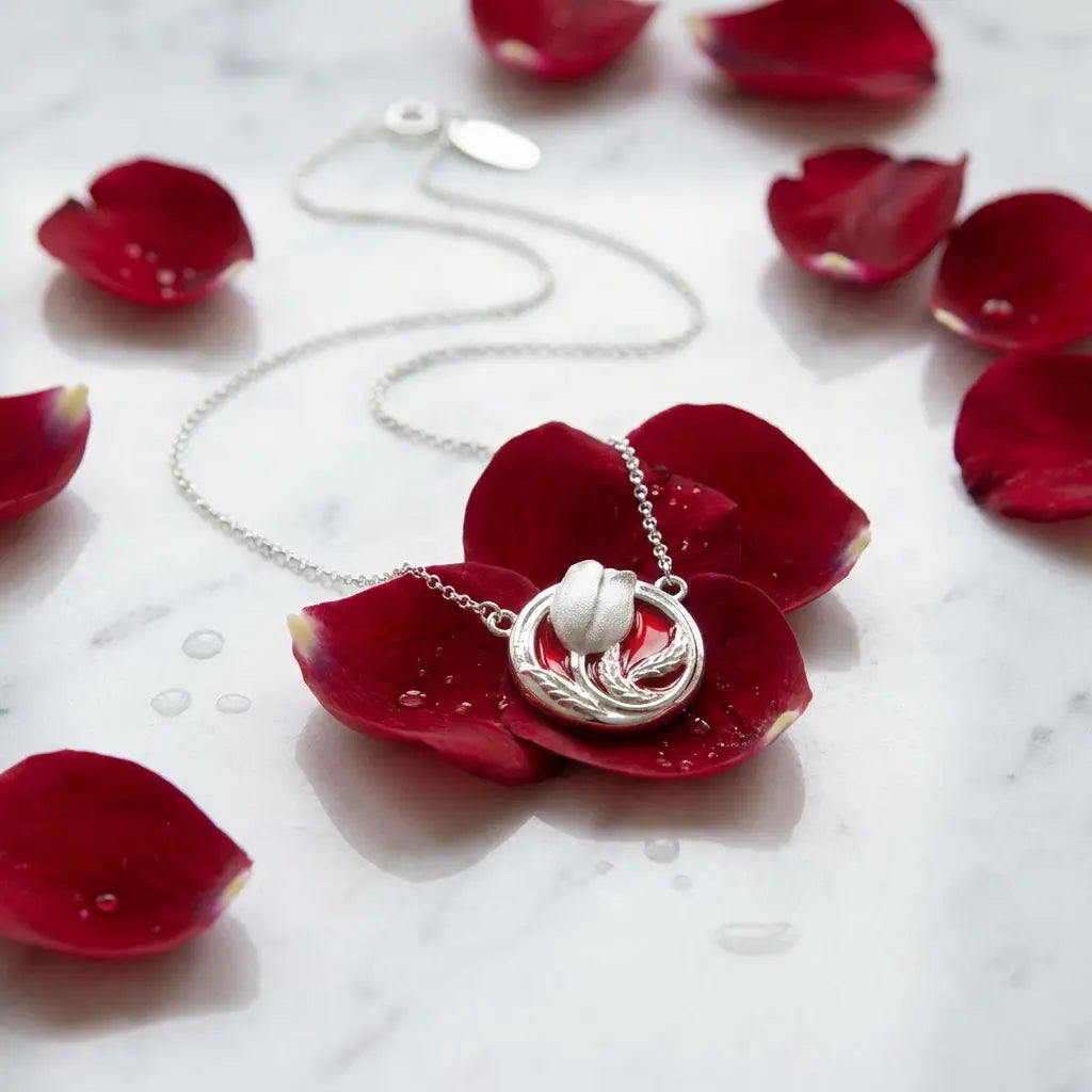 Silver necklace with a pendant on red rose petals