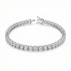 Round-cut white cubic zirconia tennis bracelet in a rhodium-plated copper setting, shown with an open box clasp on a white background