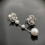 Rhodium-plated 925 silver sculpted rose stud earrings with an attached faux pearl chain drop in Dubai.