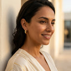 Woman wearing 18K gold vermeil crescent moon hoop earrings outdoors in DIFC Dubai.