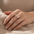 Hand modeling rose gold plated 925 silver pavé heart ring with cubic zirconia on fabric in Dubai.