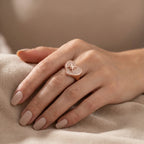 Hand modeling rose gold plated 925 silver pavé heart ring with cubic zirconia on fabric in Dubai.