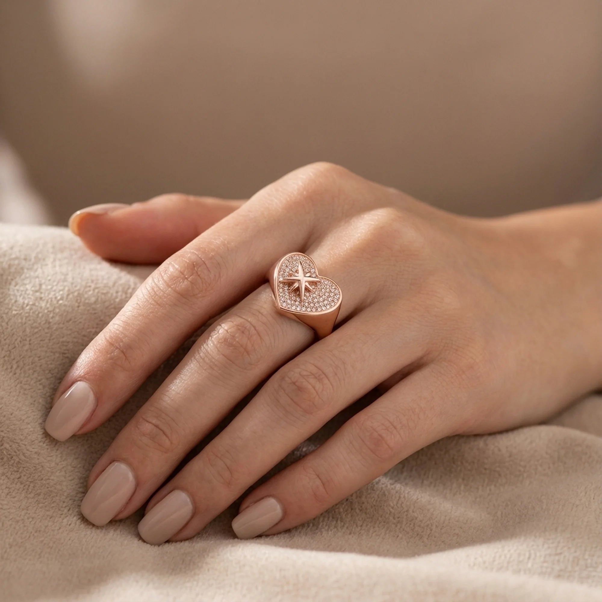 Hand modeling rose gold plated 925 silver pavé heart ring with cubic zirconia on fabric in Dubai.
