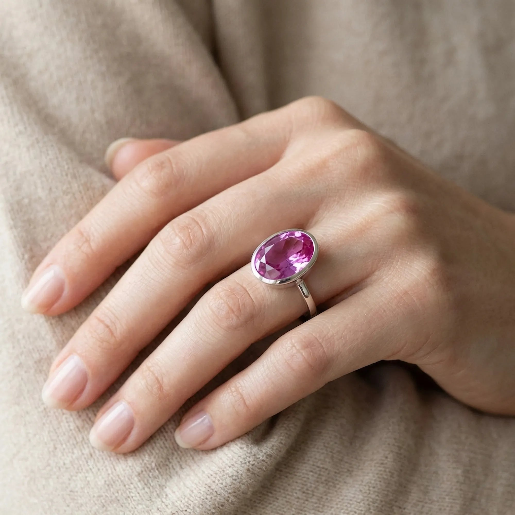 Woman holding the Large Oval Pink Purple Quartz Ring in her hands, demonstrating the striking stone size and stackable silver band scale.