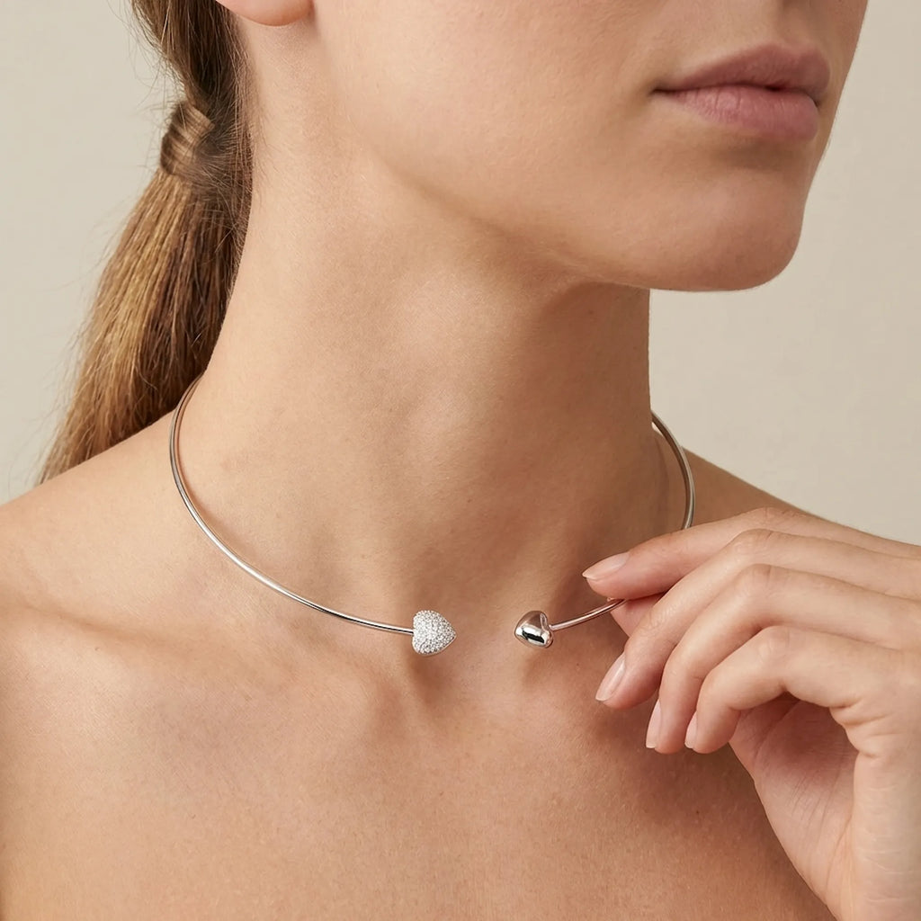 Close up of a woman adjusting the plain heart locket choker, demonstrating the fit, scale, and elegant placement on the neck.