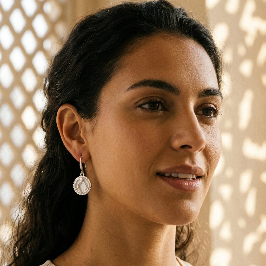 Close-up of a model wearing 925 sterling silver ouroboros snake drop earrings with a satin scale texture in Dubai.
