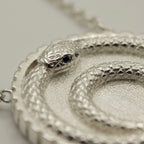 Silver ouroboros snake pendant featuring a double loop and blue topaz eye in 925 sterling silver, a milestone gift in Dubai.