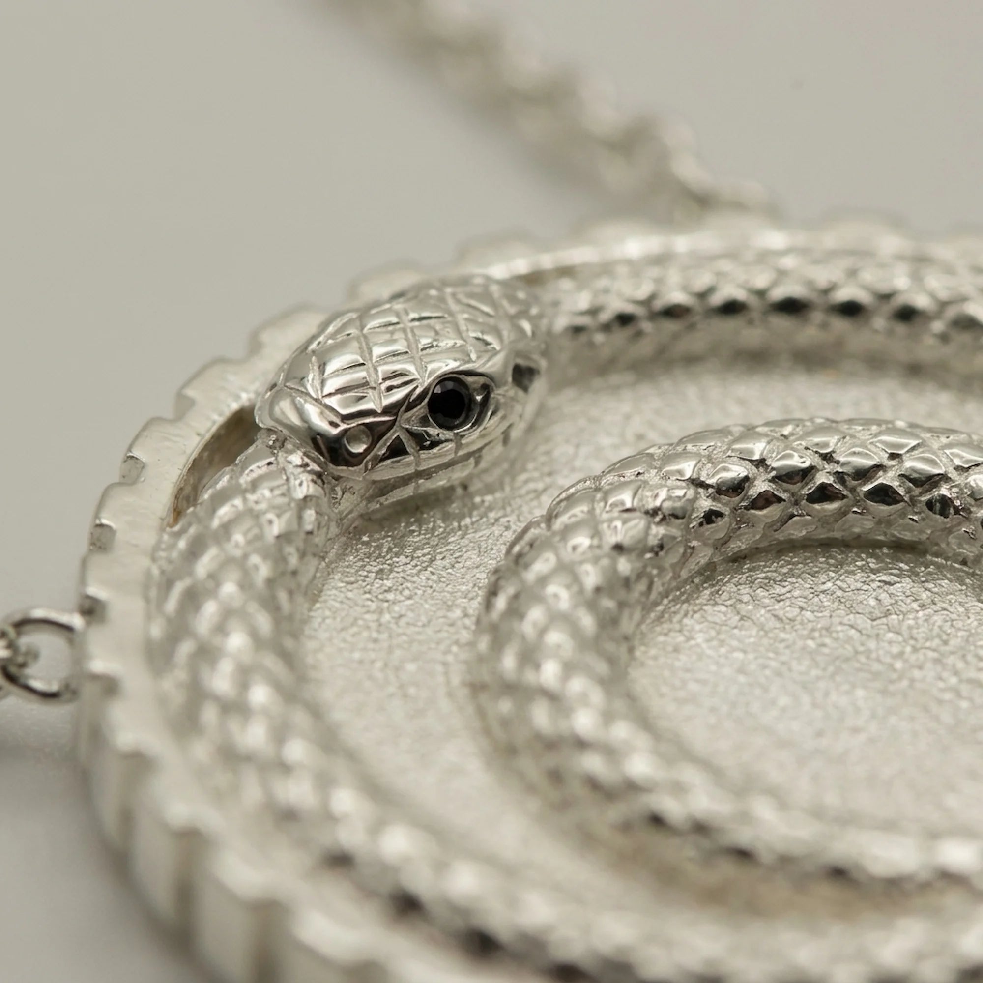 Silver ouroboros snake pendant featuring a double loop and blue topaz eye in 925 sterling silver, a milestone gift in Dubai.