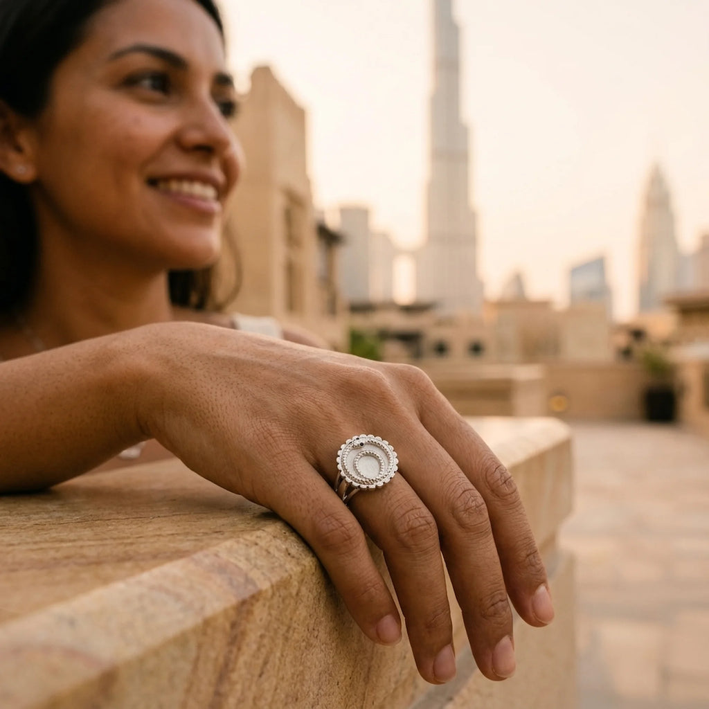 Woman wearing a 925 sterling silver ouroboros snake signet ring with a blue-topaz eye accent outdoors in Downtown Dubai.