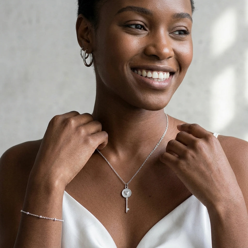 Woman wearing silver heart-and-key pendant necklace in 925 sterling silver in Dubai.