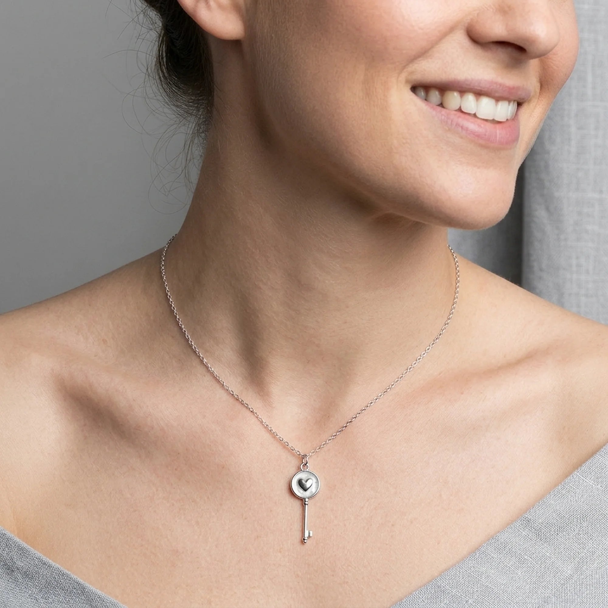 Woman wearing rhodium plated 925 sterling silver heart-and-key pendant necklace in Dubai.
