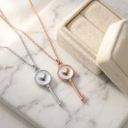 Silver and rose gold plated 925 sterling silver heart-and-key necklaces next to a jewelry box in Dubai.