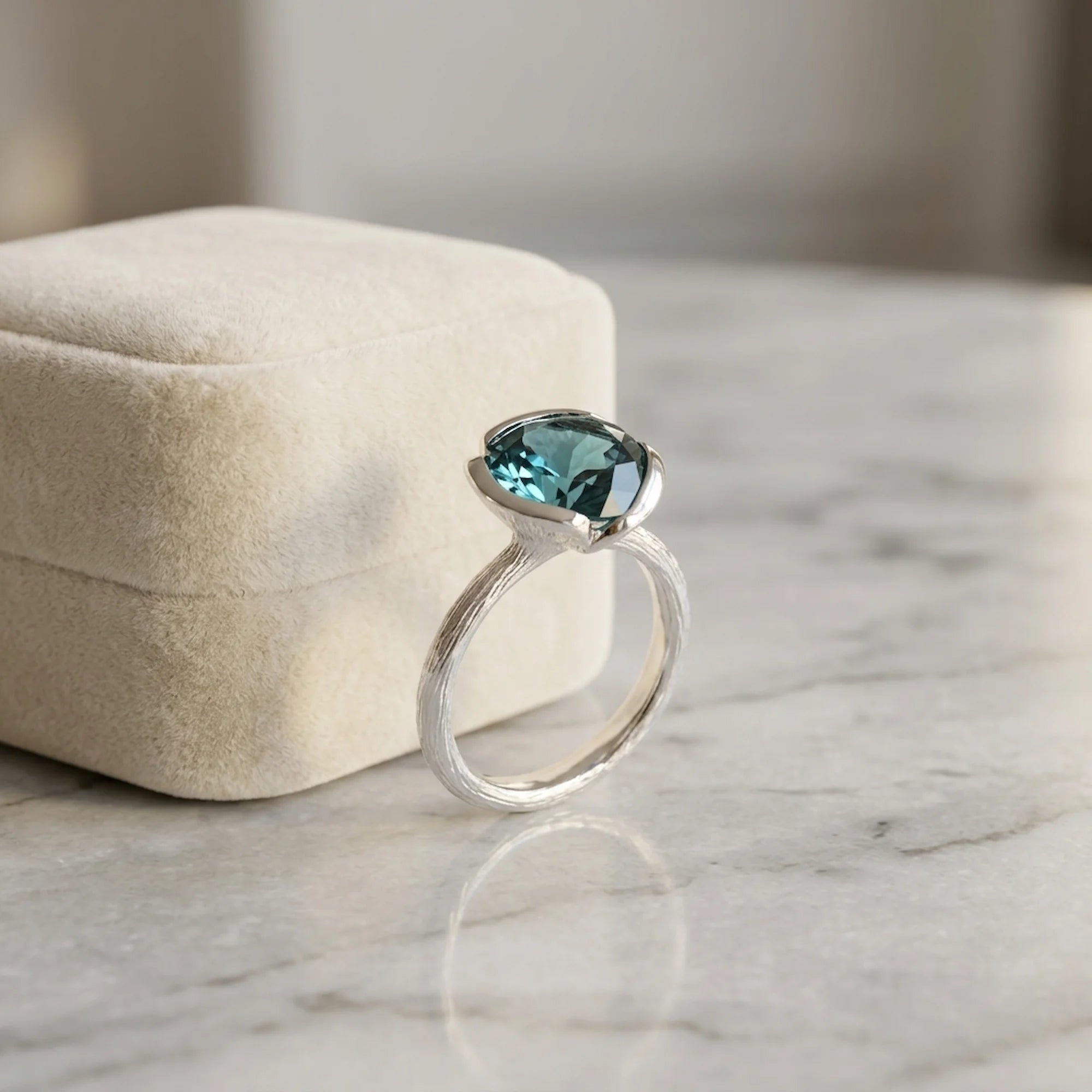 Natural sky blue topaz lotus cocktail ring in 925 sterling silver resting beside a velvet jewellery box in Dubai.