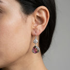 Woman wearing silver watermelon tourmaline simulant and white topaz drop earrings, an October birthday gift in Dubai.