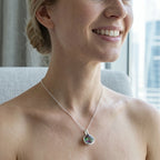 Smiling woman wearing the 925 sterling silver watermelon tourmaline simulant lotus pendant necklace in Dubai.